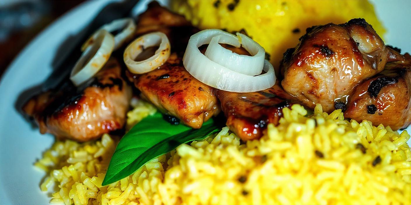 Grilled meat skewers served with yellow rice and garnished with onions and herbs.