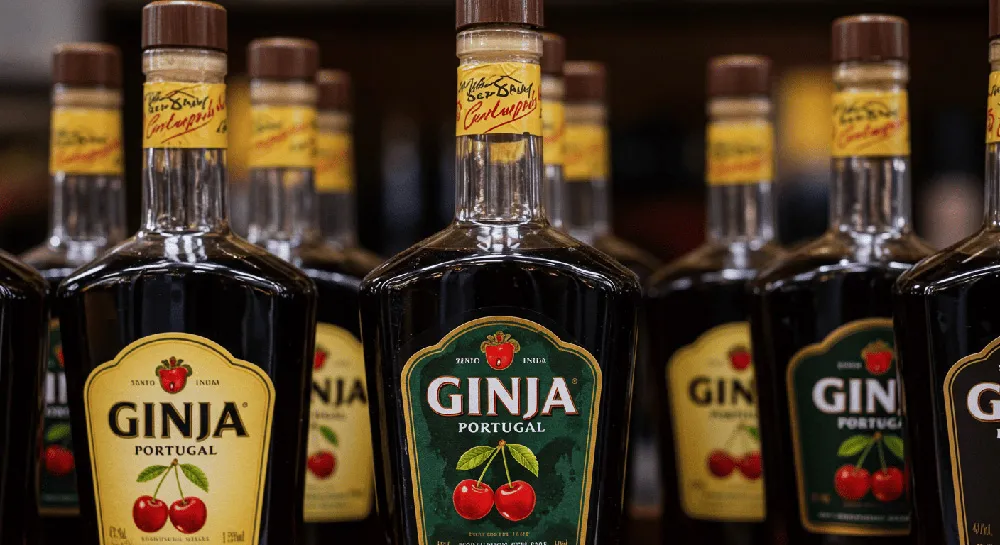 Bottles of Portuguese Ginja liqueur displayed on a wooden shelf.