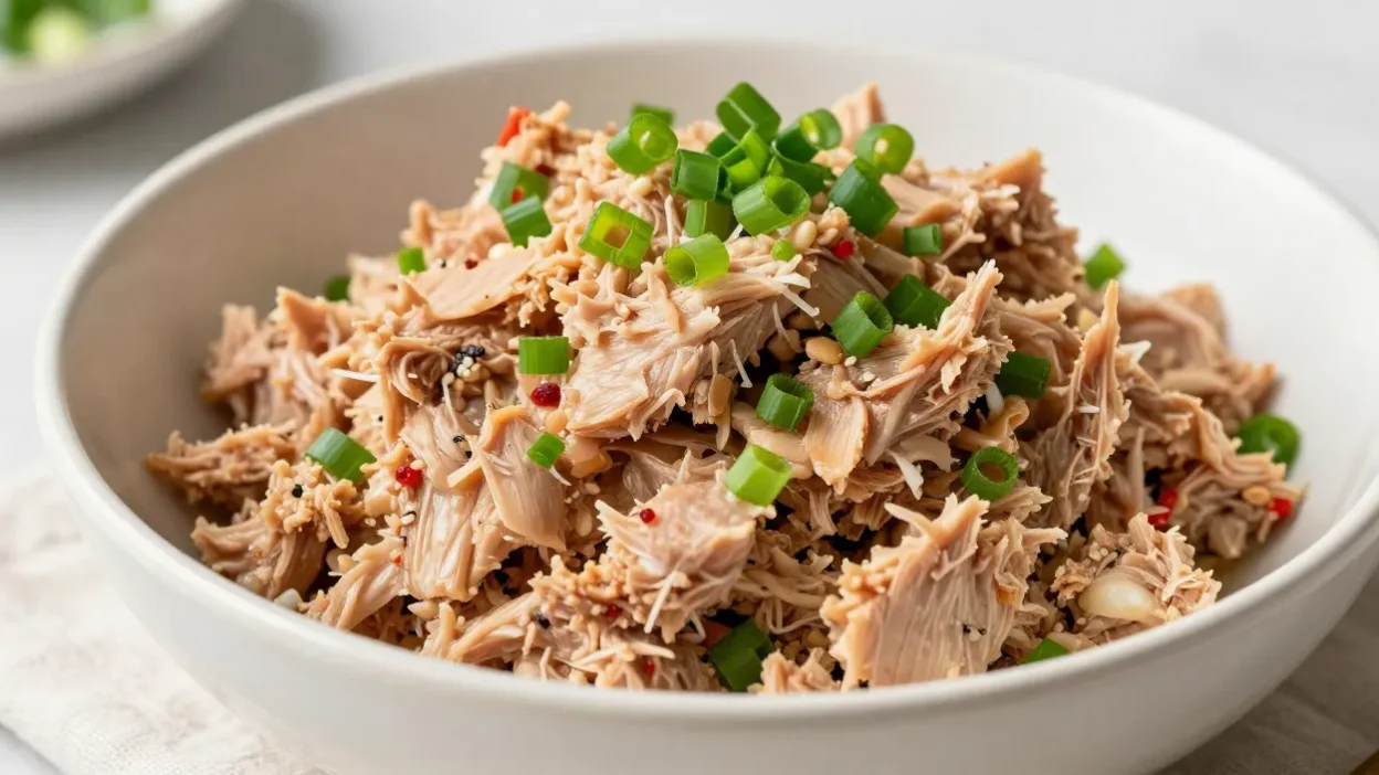 Spicy tuna salad in a bowl with green onions, shot in natural light